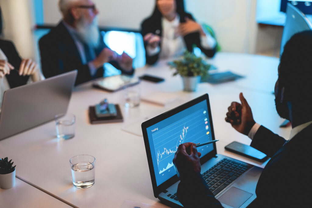 Business trader team doing blockchain analysis inside hedge fund office - Main focus on african left hand