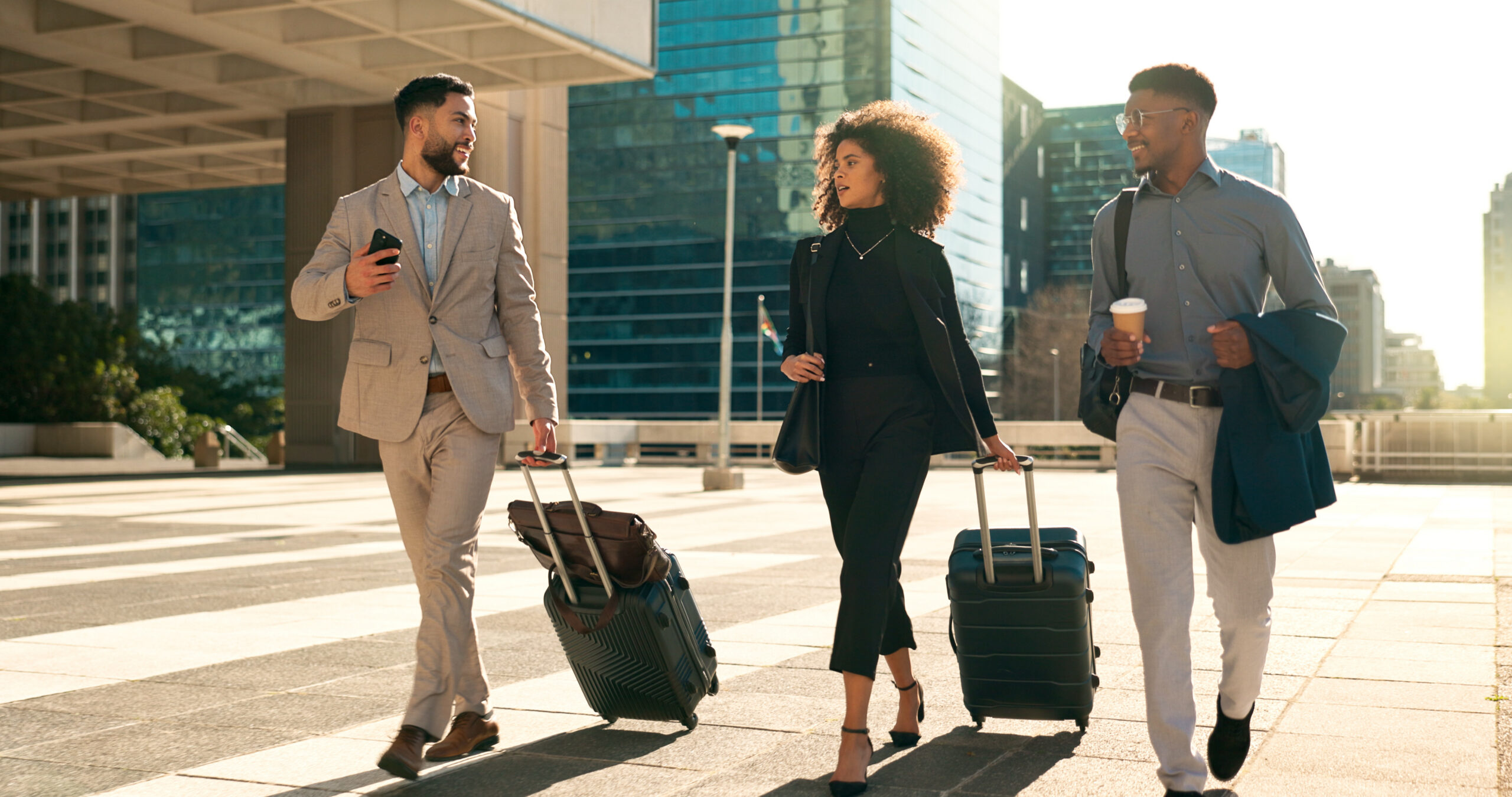 Business people, team walking and travel with suitcase in city for corporate, job opportunity and networking. Professional woman and men talking at outdoor hotel or on the way to airport with luggage